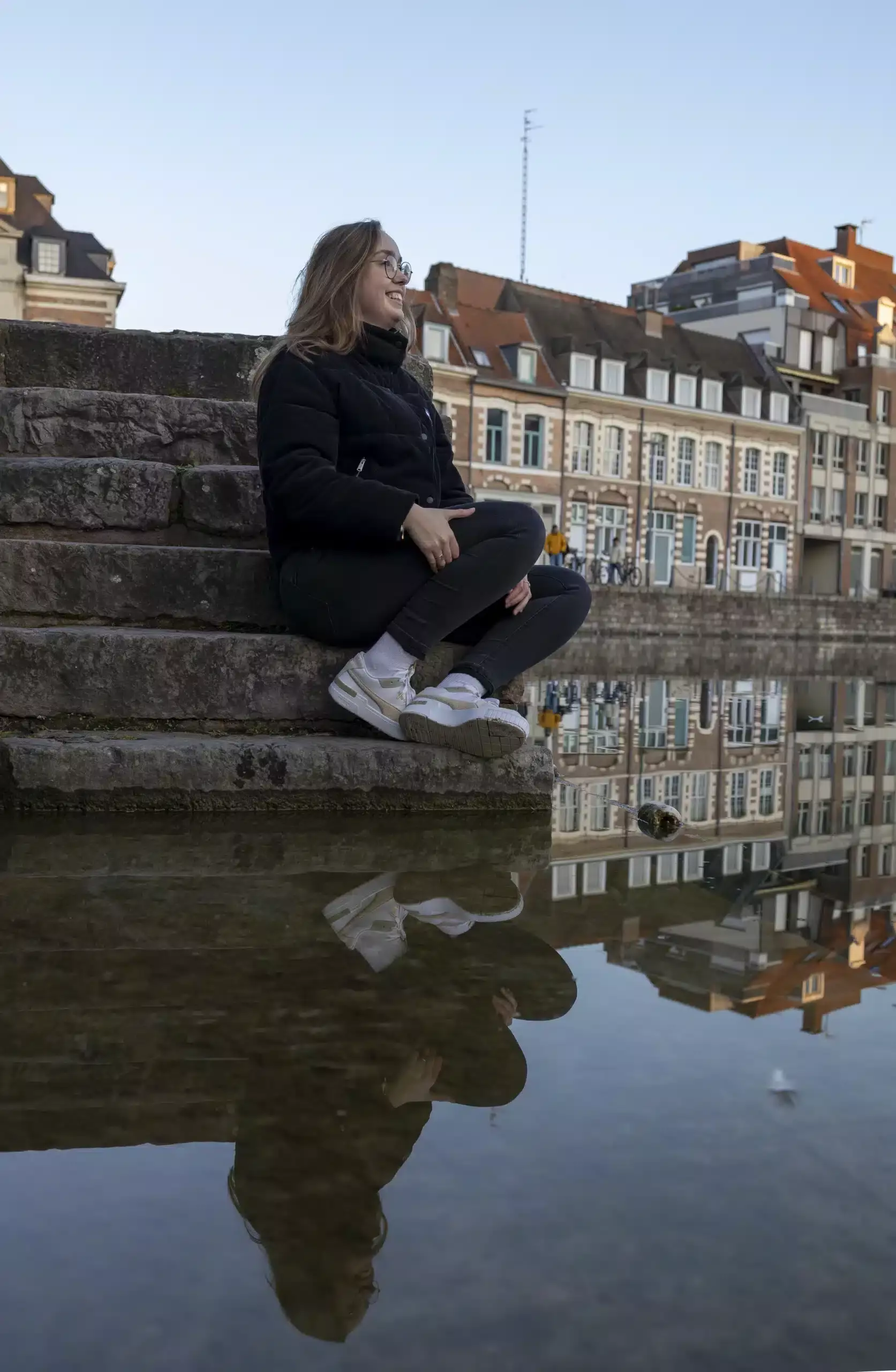 Balcon de la rivière avec une femme assise, vue urbaine à Lille.