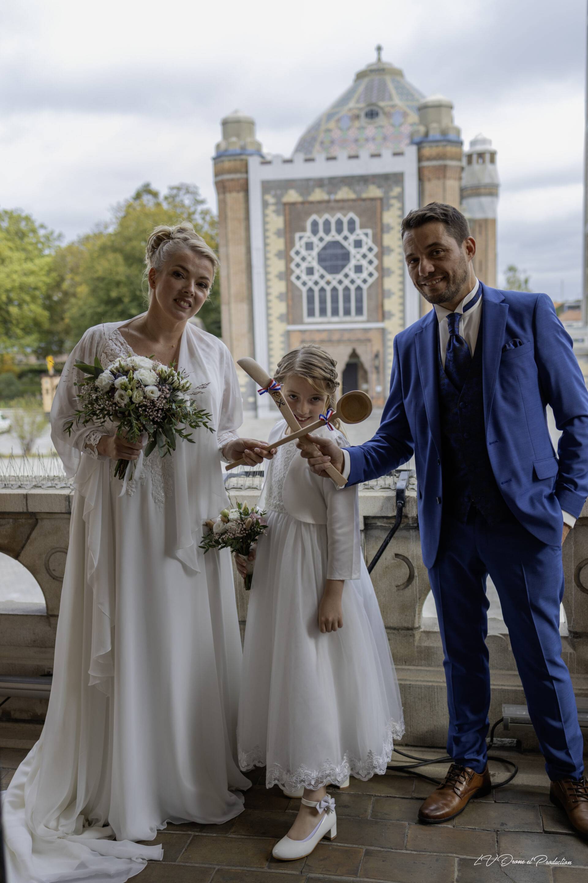 Photo de mariage avec famille à Lille, en extérieur devant un bâtiment historique.
